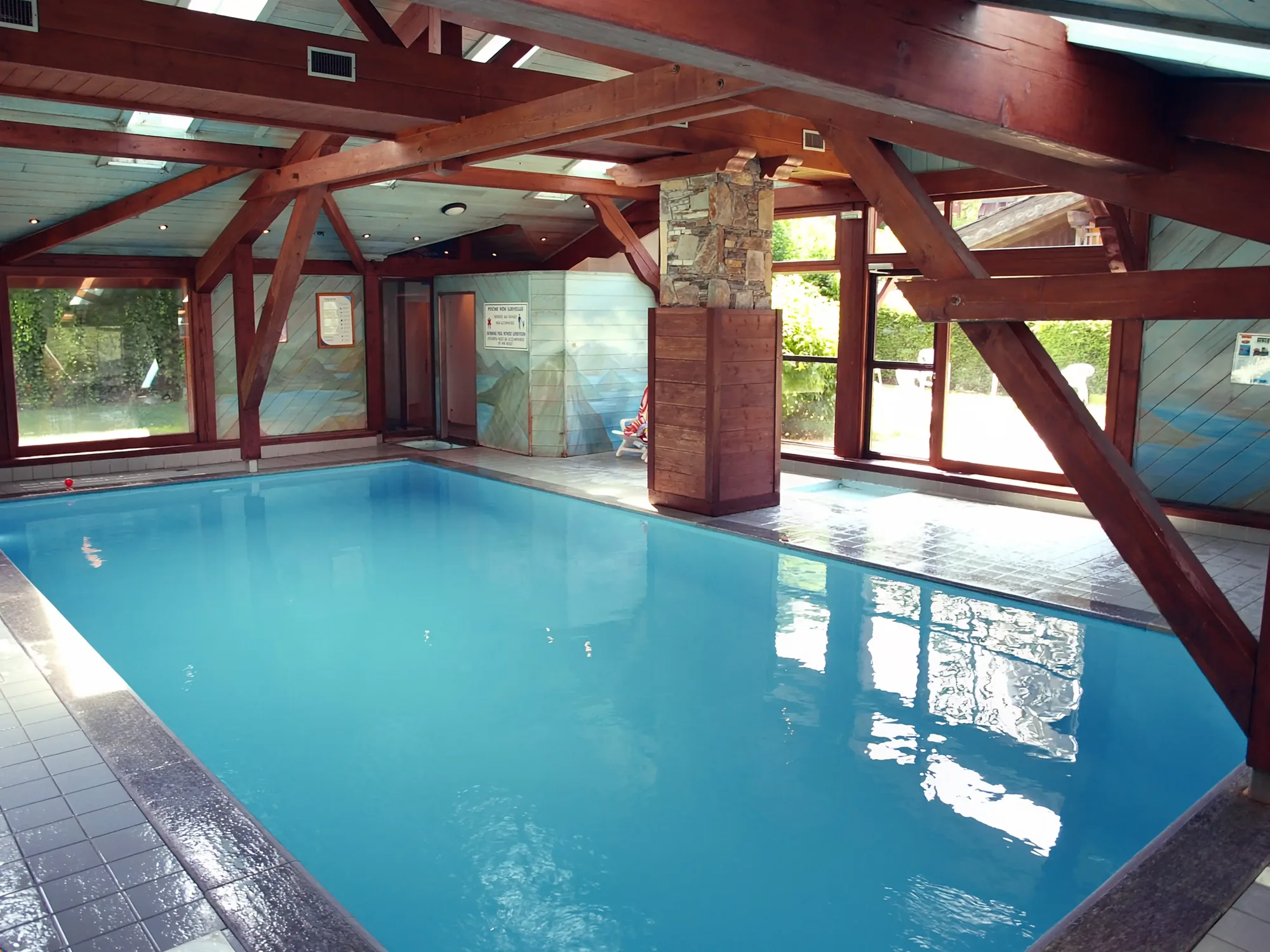 Indoor pool beneath exposed timber beams